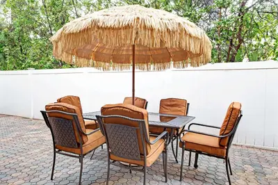 a table with chairs and a straw umbrella at Super 8 by Wyndham Kissimmee/Maingate/Orlando Area in Orlando