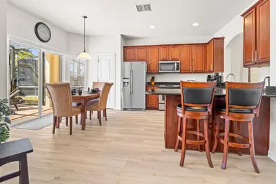 a kitchen with wooden cabinets and a table and chairs at Flagstone Villa in Orlando