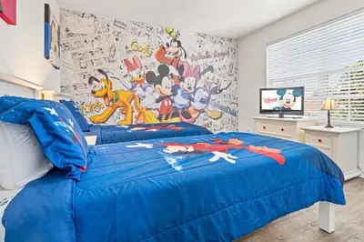 a bedroom with a blue bed with a large mural at Flagstone Villa in Orlando