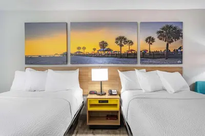 a hotel room with two beds and a table with a lamp at Days Inn by Wyndham N Orlando/Casselberry in Orlando