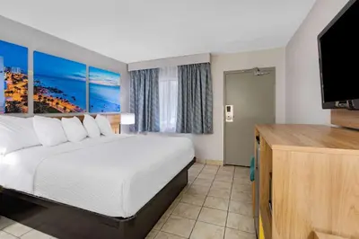 a hotel room with a bed and a flat screen tv at Days Inn by Wyndham N Orlando/Casselberry in Orlando