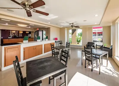 a kitchen and dining room with tables and chairs at Red Roof Inn Orlando South - Florida Mall in Orlando