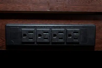 a black digital clock sitting on a wooden table at Red Roof Inn Orlando South - Florida Mall in Orlando