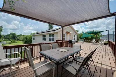 a patio with a table and chairs on a deck at Lakefront 7 Bedroom Duplex, Pool, Boat, and Hottub in Orlando
