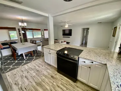 a kitchen with a counter top and a dining room at Lakefront 7 Bedroom Duplex, Pool, Boat, and Hottub in Orlando