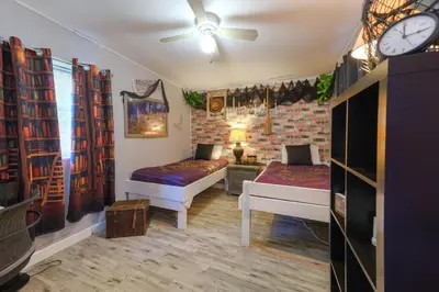 a room with two beds and a clock on the wall at Lakefront 7 Bedroom Duplex, Pool, Boat, and Hottub in Orlando