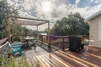a wooden deck with a picnic table and a pergola at Lakefront 7 Bedroom Duplex, Pool, Boat, and Hottub in Orlando