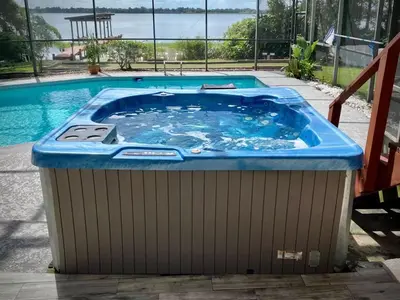 a jacuzzi tub sitting next to a swimming pool at Spacious Lakefront House with Pool, Hottub, & Boating in Orlando