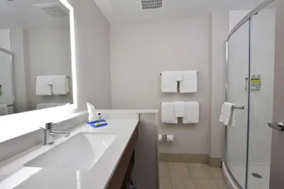a white bathroom with a sink and a shower at Holiday Inn Express & Suites - Orlando - Southeast by IHG in Orlando