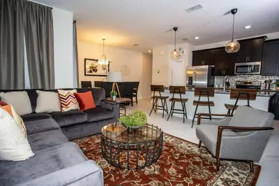 a living room with a couch and a kitchen at Four Bedrooms at StoreyLakeResort 3063 in Kissimmee