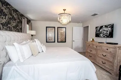 a bedroom with a large white bed and a dresser at Four Bedrooms at StoreyLakeResort 3063 in Kissimmee