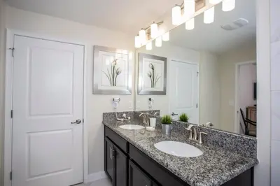 a bathroom with two sinks and a large mirror at Four Bedrooms at StoreyLakeResort 3063 in Kissimmee