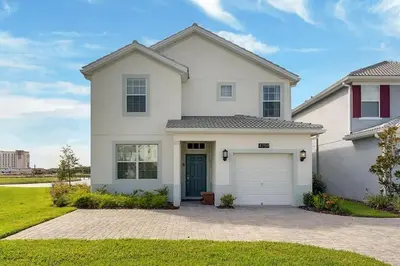 a white house with a garage at Five Bedrooms Single Family 4759 in Kissimmee