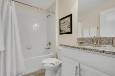 a white bathroom with a toilet and a sink and a shower at Five Bedrooms Single Family 4759 in Kissimmee