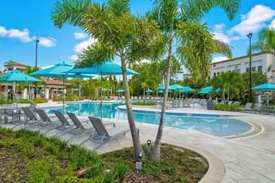 a pool at a resort with chairs and umbrellas at Shoreway Loop Unit 108 Condo in Orlando