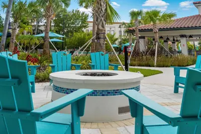 a patio with blue chairs and a fire pit at Shoreway Loop Unit 108 Condo in Orlando
