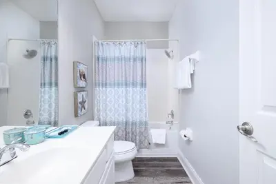 a white bathroom with a toilet and a shower at Tideview Circle Unit 38 Condo in Orlando