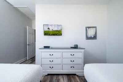 a bedroom with two beds and a white dresser at Tideview Circle Unit 38 Condo in Orlando