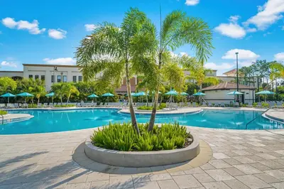 a swimming pool with a palm tree in a courtyard at Shoreway Loop Unit 407 Condo in Orlando