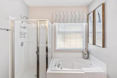 a white bathroom with a tub and a window at Sun Palm 8119 in Kissimmee