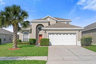 a house with a palm tree in a yard at Sun Palm 8119 in Kissimmee