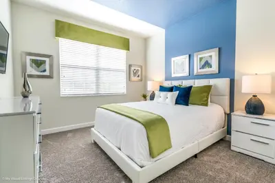 a bedroom with a bed with blue walls and a window at Beautiful Home wPrivate Pool & Spa, near WDW in Kissimmee