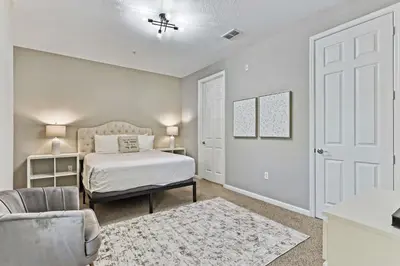 a bedroom with a bed and a chair at 4804 Cayview Ave #105 in Orlando