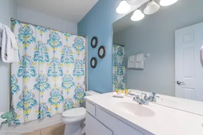 a bathroom with a sink and a toilet and a shower curtain at Lovely Townhome at Vista Cay Resort near WDW in Orlando