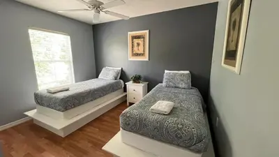 a bedroom with two beds and a window at Your Oasis Awaits! Indulge at Florida Hideaways 4BD Pool Home in Kissimmee