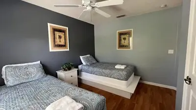 a bedroom with two beds and a ceiling fan at Your Oasis Awaits! Indulge at Florida Hideaways 4BD Pool Home in Kissimmee