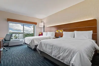 a hotel room with two beds and a window at Holiday Inn Express & Suites Orlando- Lake Buena Vista by IHG in Orlando