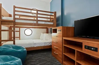 a small room with a bunk bed and a television at Holiday Inn Express & Suites Orlando- Lake Buena Vista by IHG in Orlando