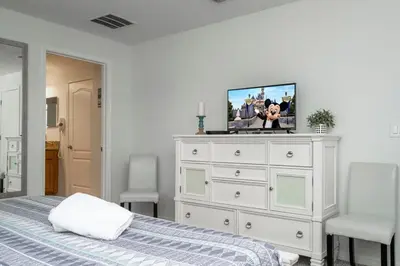 a bedroom with a white dresser with a tv on it at 8937CP-SVH in Kissimmee