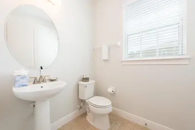 a white bathroom with a toilet and a mirror at Private Pool And Game Room With Waterpark & Resort Access At Encore Resorts Reunion - 141La in Kissimmee