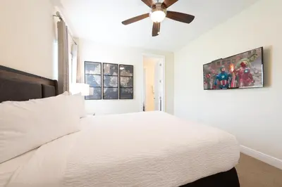 a bedroom with a white bed with a ceiling fan at Private Pool And Game Room With Waterpark & Resort Access At Encore Resorts Reunion - 141La in Kissimmee