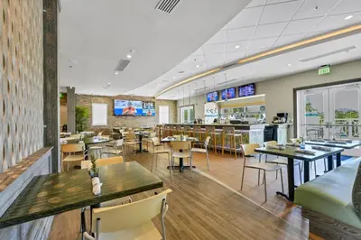 a restaurant with tables and chairs and a bar at Elegant Home Near Disney With Private Pool And Waterpark & Resort Access At Encore Resorts Reunion - 7393Mr in Kissimmee