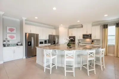 a kitchen with a large island with white cabinets at Exquisite Home With Theater, Themed Rooms Near Disney With Waterpark & Resort Access At Encore Resort- 7664Ff in Kissimmee