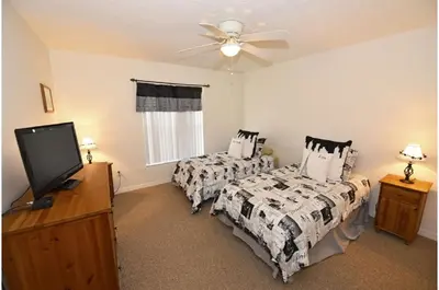 a bedroom with two beds and a flat screen tv at Holiday Villas of Kissimmee in Kissimmee