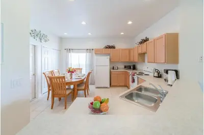 a kitchen with a table and chairs and a kitchen with a sink at Holiday Villas of Kissimmee in Kissimmee