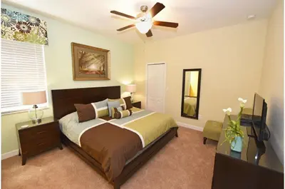 a bedroom with a bed and a ceiling fan at Holiday Villas of Kissimmee in Kissimmee