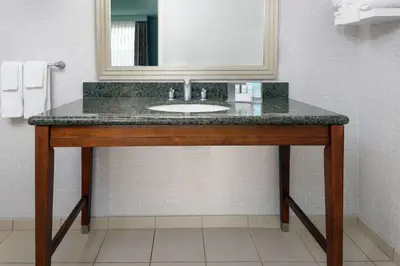 a bathroom with a sink and a mirror at Hampton Inn & Suites Orlando Airport at Gateway Village in Orlando