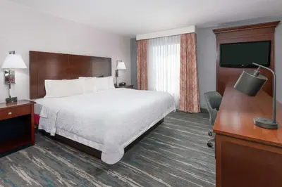 a hotel room with a bed and a flat screen tv at Hampton Inn & Suites Orlando Airport at Gateway Village in Orlando