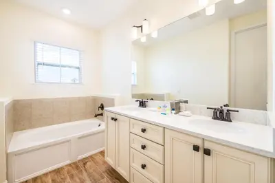 a bathroom with a tub and a sink and a bath tubermottermott at Margaritaville Cottages Orlando by Rentyl with H2O Waterpark in Kissimmee