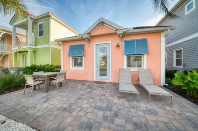 a patio with a table and chairs in front of a house at Margaritaville Cottages Orlando by Rentyl with H2O Waterpark in Kissimmee