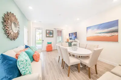 a living room with a table and a couch at Margaritaville Cottages Orlando by Rentyl with H2O Waterpark in Kissimmee