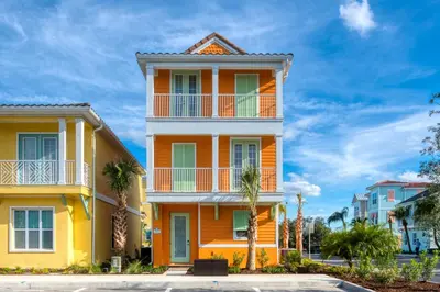 a yellow house with palm trees in front of it at Margaritaville Cottages Orlando by Rentyl with H2O Waterpark in Kissimmee