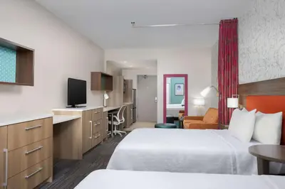 a hotel room with two beds and a flat screen tv at Home2 Suites By Hilton Clermont in Clermont