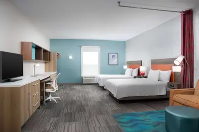 a hotel room with two beds and a flat screen tv at Home2 Suites By Hilton Clermont in Clermont