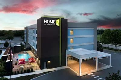 a hotel building with a bench in front of it at Home2 Suites By Hilton Clermont in Clermont