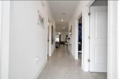 a hallway with white walls and white floors and doors at Storey Lake Resort Just 5 Minutes to Mickey Mouse in Kissimmee
